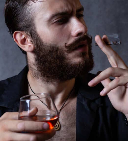 Мужчина курит и пьёт алкоголь